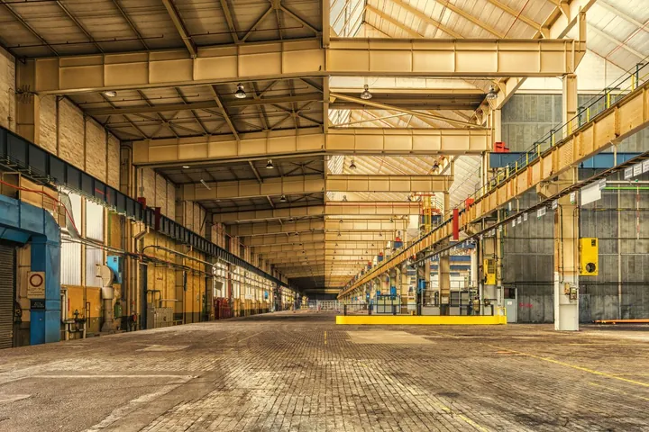 Weitläufige Industriehalle mit Betonboden vor der Hallenreinigung